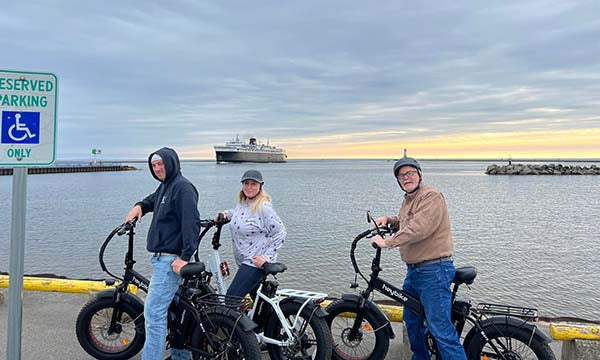 A senior and his friend are riding an heybike ebikes by the port