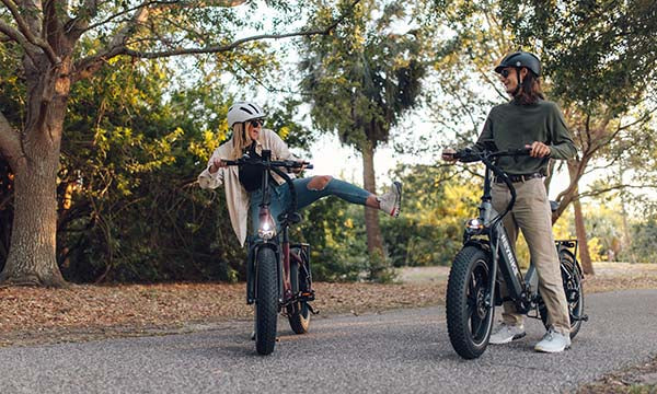 The man and the girl wearing helmets are riding the Ranger S e-bike during the fall season
