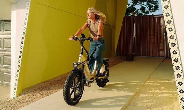 a short female is riding step-thru electric bike