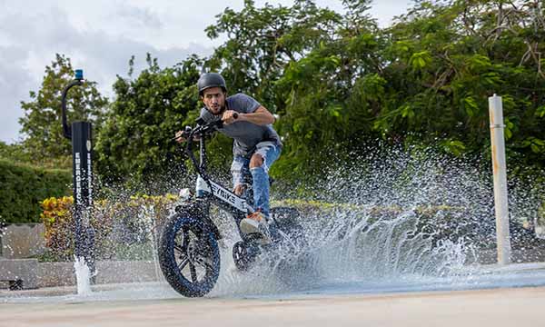 A man is riding a Tyson e-bike across the puddle