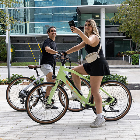 man and woman are riding their ebike on the city