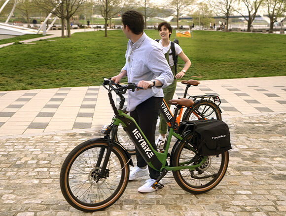A man and a woman are pushing their Heybike electric bikes.