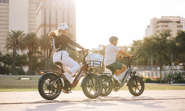 a man and girl are riding Range S foldable ebike on city road