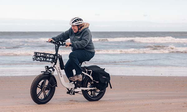 a woman is riding Mars fat tire ebike on the beach