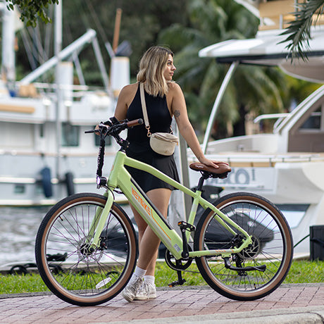 a woman is pushing her green sola ebike