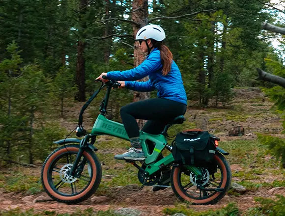 A woman exploring the forest on a electric folding bicycle