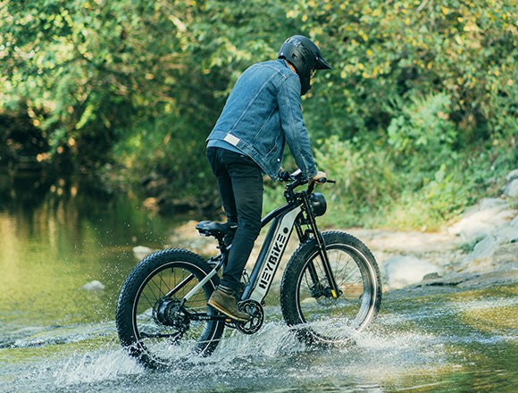 a man is riding Brawn ebike cross over on the river