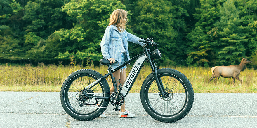 A girl is pushing a Brawn electric bicycle on the road